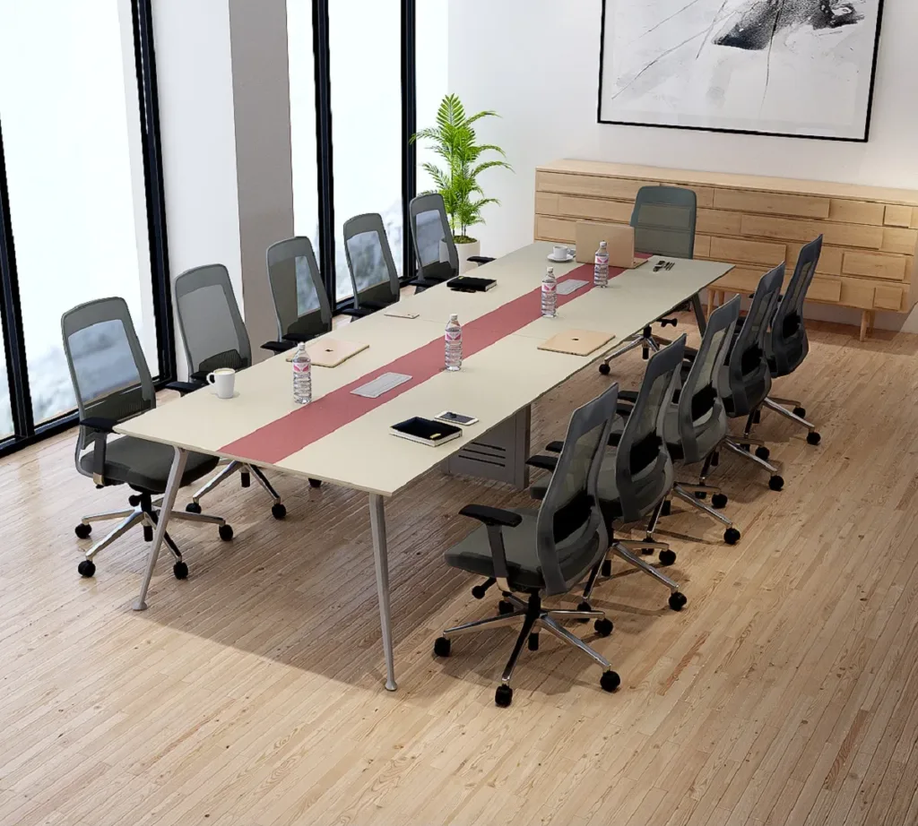 A modern conference room featuring a long conference table for office, ten chairs, water bottles, notebooks, and laptops. Large windows brighten the space, which includes a plant, artwork, wooden floors, and a side cabinet.